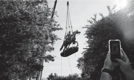  ?? Erin Edgerton / Associated Press ?? The monument of Stonewall Jackson is lifted from its pedestal on Saturday in Charlottes­ville, Va. The removal of the Lee and Jackson statues comes nearly four years after violence erupted at the infamous “Unite the Right” rally.