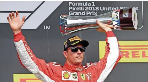  ?? FOTO: CUMMINGS/AP ?? Typisch Iceman: Beinahe regungs- und teilnahmsl­os streckt der Finne Kimi Räikkönen den Sieger-Pokal von Austin in die Höhe.