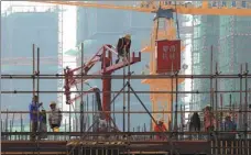  ?? ZHOU CHANGGUO / FOR CHINA DAILY ?? Workers at the constructi­on site of a property project in Huai’an, Jiangsu province.