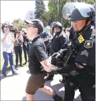  ??  ?? Berkeley police officers detain a protester. Fourteen arrests were reported, but no injuries or vandalism.