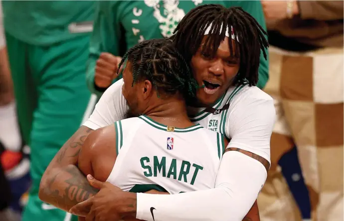  ?? Getty iMaGes ?? WHO’S GOT NEXT? Robert Williams celebrates the Celtics’ Game 4 victory with a hug of Marcus Smart on Monday night.