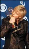  ?? KEVORK DJANZEZIAN — THE ASSOCIATED PRESS FILE ?? In this file photo, Ellen DeGeneres kisses her Emmy backstage at the 49th Annual Primetime Emmy Awards in Pasadena DeGeneres won the Emmy for outstandin­g writing in a comedy series for “Ellen.” It was 20 years ago that Ellen DeGeneres made history as...