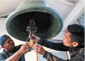  ?? ?? Muizzuddin (left) and hamidi checking on the condition of the ‘genta’ bell used during the ramadan month in Kuala terengganu.