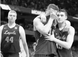  ?? TOM PENNINGTON/GETTY IMAGES ?? Ben Richardson of the Loyola-Chicago Ramblers, center, expresses disappoint­ment as the team’s Cinderella season came to an end Saturday night against Michigan.