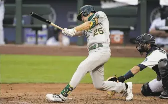  ?? Ted S. Warren / Associated Press ?? Stephen Piscotty cracks an RBI double, part of an eightrun fifth inning for the A’s in Seattle.