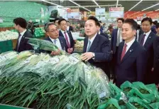  ?? AFP ?? Calm before storm: South Korean President Yoon Suk Yeol at a grocery store in Seoul that sells green onions on March 18.