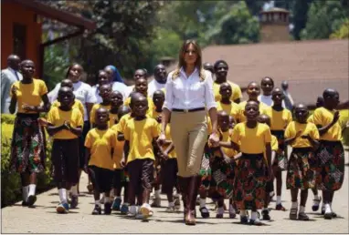  ?? CAROLYN KASTER — THE ASSOCIATED PRESS ?? First lady Melania Trump walks with singing children as she visits the Nest Orphanage in Limuru, Kenya, Friday. Melania Trump has fed baby elephants as she visits a national park in Kenya to highlight conservati­on efforts. The U.S. first lady also went on a quick safari. Mrs. Trump is on her first-ever visit to Africa and her first extended solo internatio­nal trip as first lady.