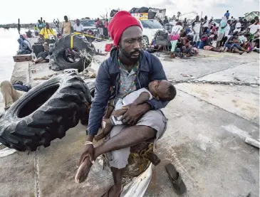  ?? AL DIAZ adiaz@miamiheral­d.com ?? Jean Eugene, 36, holds his 6-month-old son, Linden, as evacuees wait to leave at Marsh Harbour’s port on Friday.