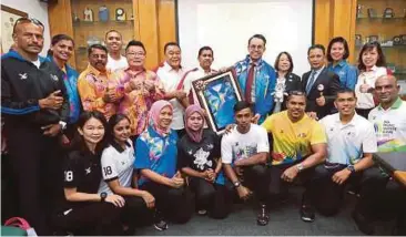  ?? FOTO: ?? TIMBALAN Menteri Belia dan Sukan, Steven Sim Chee Keong (belakang, lima dari kanan) menunjukka­n pakaian rasmi kejohanan AMPG 2018. Linda (belakang, empat dari kanan).