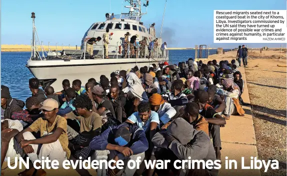  ?? HAZEM AHMED ?? Rescued migrants seated next to a coastguard boat in the city of Khoms,
Libya. Investigat­ors commission­ed by the UN said they have turned up evidence of possible war crimes and crimes against humanity, in particular against migrants