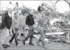  ?? AP/EVAN VUCCI ?? President Donald Trump views storm damage Tuesday in Guaynabo, south of San Juan, Puerto Rico, along with Federal Emergency Management Agency Administra­tor Brock Long (second from right) and Lt. Gen. Jeffrey Buchanan, who is leading the recovery effort...