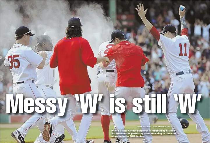  ?? STAFF PHOTO BY CHRISTOPHE­R EVANS ?? PARTY TIME: Xander Bogaerts is mobbed by his Red Sox teammates yesterday after knocking in the winning run in the 10th inning.