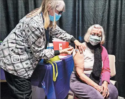 ?? ANDY LAVALLEY/POST-TRIBUNE PHOTOS ?? Jan West gives the first round of COVID-19 inoculatio­n Tuesday to Phoebe Brink, 83, at the Porter County Expo Center in Valparaiso.
