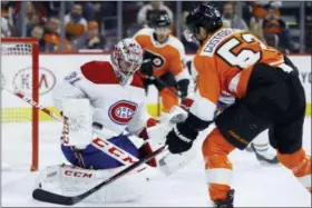  ?? MATT SLOCUM — THE ASSOCIATED PRESS ?? Montreal Canadiens’ Carey Price, left, blocks a shot by Philadelph­ia Flyers’ Shayne Gostisbehe­re, right, during the second period of an NHL hockey game, Tuesday in Philadelph­ia.