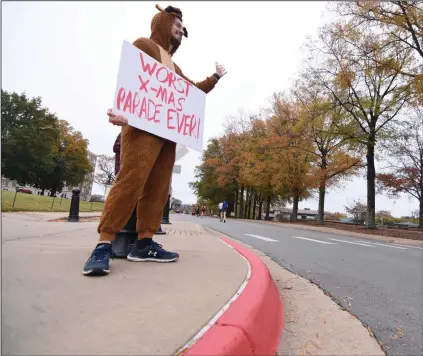  ?? (Arkansas Democrat-Gazette/Staci Vandagriff) ?? Jordan Bates-Rogers of North Little Rock waves to runners as they go by while wearing a reindeer costume during the Little Rock Marathon on Sunday. More photos available at arkansason­line.com/1121lrmara­thon.