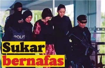  ??  ?? TERTUDUH Doan Thi Huong diiring anggota polis keluar selepas menghadiri perbicaraa­n, semalam.