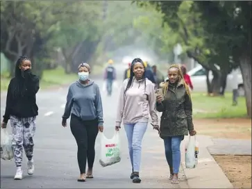  ?? Denis Farrell Associated Press ?? TSHWANE University of Technology students in Pretoria, South Africa, return to their residence Saturday. Vaccinatio­n has lagged among younger adults in the nation: In the 18-to-34 age group, only 22% are inoculated.