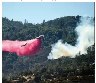  ?? AP/JOSH EDELSON ?? A spotter plane banks in front of an air tanker as it drops fire retardant on a burning hillside during the Ranch Fire in Clearlake Oaks, Calif., on Sunday.