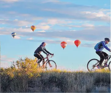  ??  ?? Cyclists ride on a city bike path on their way to the Albuquerqu­e Internatio­nal Balloon Fiesta. Boosting the city’s business profile is a goal of Albuquerqu­e’s two mayoral candidates.