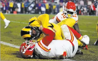  ?? Kelvin Kuo ?? The Associated Press Rams linebacker Samson Ebukam scores a touchdown after intercepti­ng a pass from Chiefs quarterbac­k Pat Mahomes, bottom, in the third quarter of Los Angeles’ 54-51 home victory Monday.