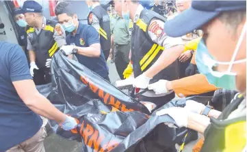  ??  ?? Indonesian policemen carry a body bag containing the remains of a passenger on board the ill-fated Lion Air flight JT 610, at the Jakarta port in Jakarta.