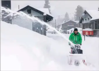  ?? GEORGE FREY / AFP ?? Snow is removed with a blower at the Big Bear Mountain Resort, California, on Feb 25. Rare winter storms swept the US state causing mass power outages, flooding and the closures of motorways and beaches. More than 120,000 people — many of them in the Los Angeles area — were without electricit­y on Feb 26 after days of fierce winds.