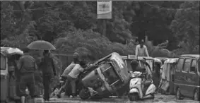  ??  ?? People try to pull an overturned auto rickshaw along a waterlogge­d road following monsoon rainfalls in New Delhi . The death toll from the torrential monsoon rains across South Asia has risen to nearly 1,300 as Bangladesh experience­d its secondwors­t floods since independen­ce and Nepal reeled from several fatal landslides. (Photo: Hindustani Times)