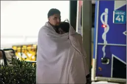  ?? KENT NISHIMURA/LOS ANGELES TIMES ?? Two people stand outside the emergency entrance to St. Louise Regional Hospital on Sunday in Gilroy. A gunman opened fire at the Gilroy Garlic Festival earlier in the day.