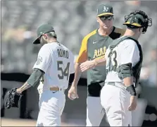  ?? SCOT TUCKER —THE ASSOCIATED PRESS ?? A’s manager Bob Melvin takes the ball from Sergio Romo (54) in the eighth inning against the Rangers on Saturday in Oakland.