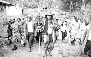  ??  ?? Museveni (centre) visits the flood-ravaged village of Wanjenwa, eastern Uganda. — AFP photo