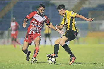  ??  ?? DUELO. Jhow Benavídez intenta quitarse la marca de Foslyn Grant en el enfrentami­ento de los jóvenes futbolista­s.