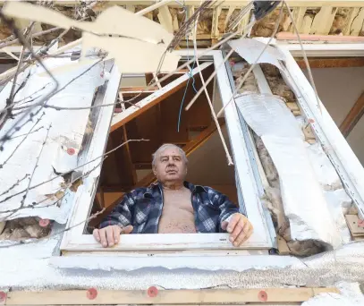  ?? Picture: AFP ?? EYE OF A STORM. A man looks out of the window of his partially destroyed house on the outskirts of Odessa on Monday after shelling by Russian warships.