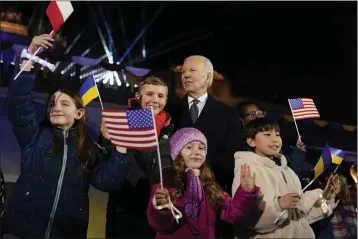  ?? EVAN VUCCI — THE ASSOCIATED PRESS ?? President Joe Biden stands with children after delivering a speech marking the one-year anniversar­y of the Russian invasion of Ukraine on Tuesday during a visit to the Royal Castle Gardens in Warsaw.