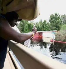  ??  ?? Visual evidence: A man taking a picture of floodwater­s in Bucksport, South Carolina.