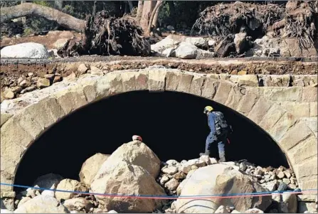  ?? Photograph­s by Wally Skalij Los Angeles Times ?? AN L.A. COUNTY search and rescue team surveys the boulders and debris under Ashley Road in Montecito, Calif., on Thursday.