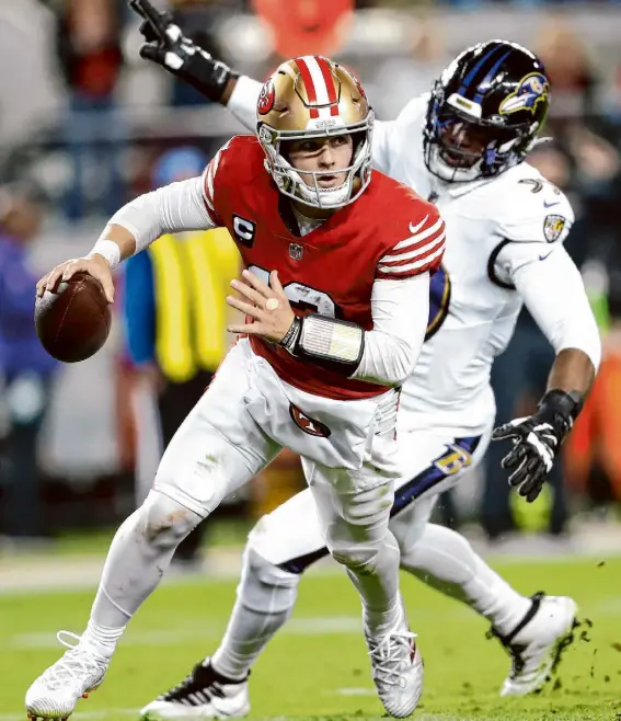  ?? Scott Strazzante/The Chronicle ?? 49ers quarterbac­k Brock Purdy scrambles before throwing his third intercepti­on of the first half during the loss to the Ravens on Monday. Purdy finished with four intercepti­ons — the first time he has thrown four intercepti­ons playing football at any level.