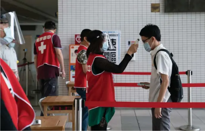  ?? © Ashley Pon/nyt ?? Screening op koorts bij leerlingen in een school in Taipei. Taiwan pakte de uitbraak snel en doeltreffe­nd aan door de inzet van controles en technologi­e.