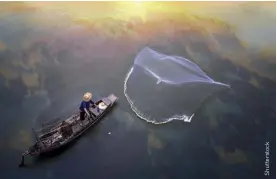  ??  ?? ABOVE A fishermen casting his net