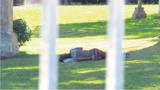  ?? Photo: Stefan Goosen ?? Knysna residents are fed-up with vagrants making themselves at home anywhere they find a space, such as this man caught on camera while sleeping on the St George’s Anglican Church premises in Main Road recently.