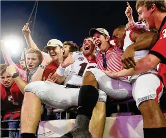  ?? BOB ANDRES / ROBERT.ANDRES@AJC.COM ?? Georgia quarterbac­k Jake Fromm (11) celebrates in the stands with fans after leading a crucial 24-17 victory over Florida on Saturday in Jacksonvil­le, Fla.