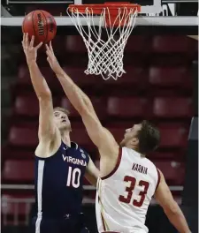  ??  ?? GOT IT: BC’s James Karnik gets a piece of the shot from Virginia’s Sam Hauser during the second half.