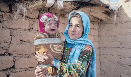  ?? MSTYSLAV CHERNOV/AP ?? Qandi Gul and her brother outside their home near Herat, Afghanista­n. The girl’s father sold her into marriage to feed his family.