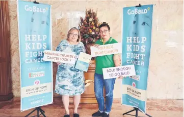  ??  ?? Hee (left) and her assistant secretary Shirley Ariffin posing with pledge cards and supportive placards after the press conference.