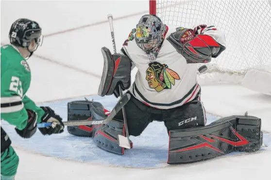  ?? BRANDON WADE/AP ?? Blackhawks goalie Corey Crawford stops a shot by Stars defenseman Esa Lindell during the second period Sunday in Dallas. He had 31 saves on 33 shots.