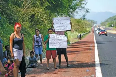 ?? AP PHOTO/MARCO UGARTE ?? On Friday, two days after the passage of Hurricane Otis, residents hold signs that read “We need food. Support. We are homeless” in Los Coyotes, near Acapulco, Mexico.