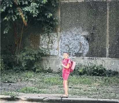  ?? JLEB GMRMNICH / RShtSrs ?? Una nena davant d’una escola bombardeja­da ahir a Kostiantin­ivka, a la província de Donetsk