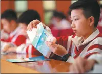  ?? PROVIDED TO CHINA DAILY ?? A middle school student opens a letter from a volunteer in Xinyu, Jiangxi province, in April last year. More than 700 students from the city participat­ed in the program, which invites adult volunteers to bond one-on-one with students via letters to help with their mental health.