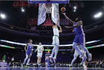  ?? MATT SLOCUM — THE ASSOCIATED PRESS ?? Philadelph­ia 76ers' Joel Embiid, right, goes up for a shot against Boston Celtics' Derrick White during the first half on Wednesday in Philadelph­ia.