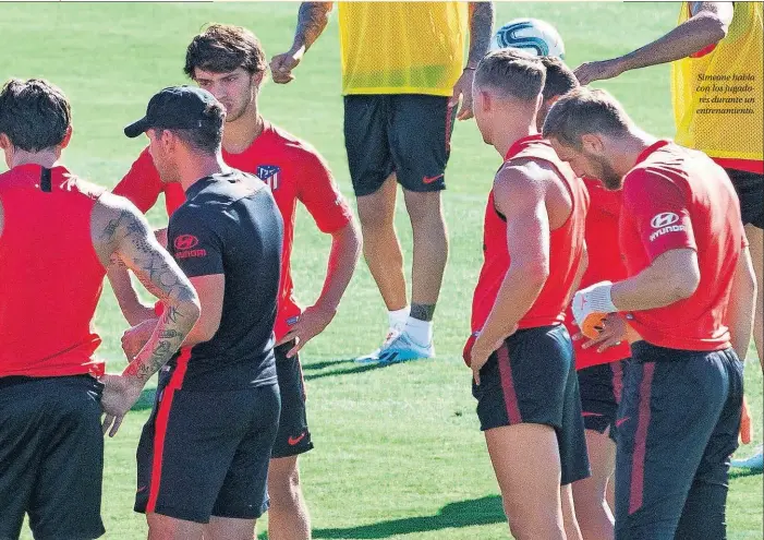  ??  ?? Simeone habla con los jugadores durante un entrenamie­nto.