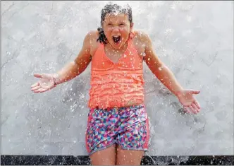  ?? The Associated Press ?? A girl cools off in the Internatio­nal Fountain at the Seattle Center on Wednesday. Seattle is expecting temperatur­es this week in the 30s while Portland is expected to top 40.